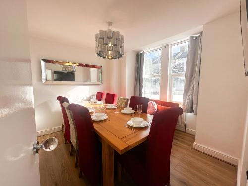 a dining room table with red chairs and a dining room table at Stay In Tooting in London