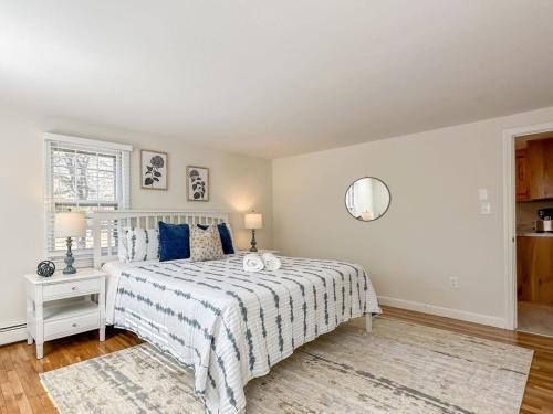 a white bedroom with a bed and a mirror at 2 Miles to Nauset & Coast Guard Beach Dog Friendly in Eastham