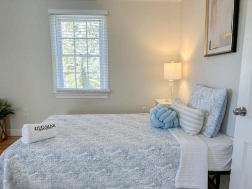 a bedroom with a bed and a lamp and a window at 2 Miles to Nauset & Coast Guard Beach Dog Friendly in Eastham
