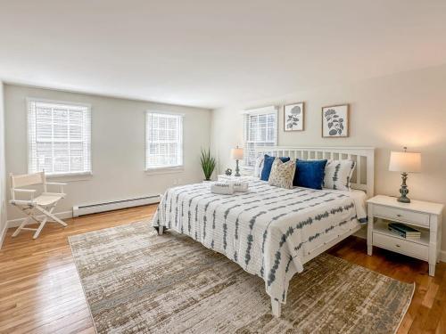 a white bedroom with a bed with blue pillows at 2 Miles to Nauset & Coast Guard Beach Dog Friendly in Eastham