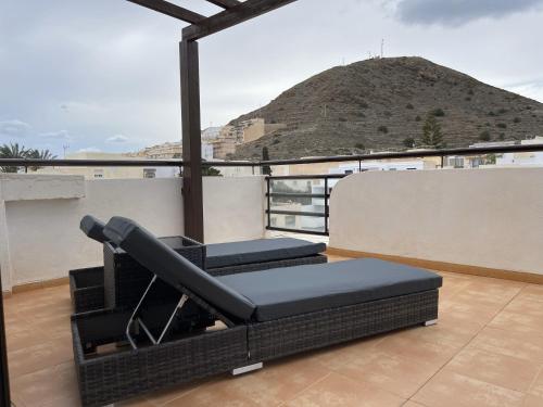 een balkon met 2 stoelen en uitzicht op een berg bij Ático Carboneras con fantástica terraza in Carboneras