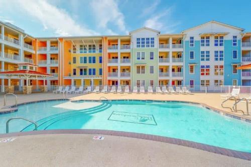 an image of a swimming pool at a resort at Sojourn Relaxing Condo near the Beach with Pool in Virginia Beach