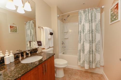 a bathroom with a sink and a toilet and a shower at Sojourn Relaxing Condo near the Beach with Pool in Virginia Beach