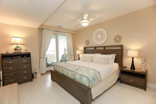 a bedroom with a bed and a dresser and a window at Sojourn Relaxing Condo near the Beach with Pool in Virginia Beach