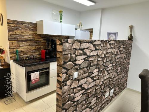 a kitchen with a stone wall at Danube Island Apartment 3 in Vienna