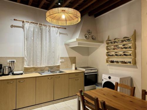 una cucina con lavandino, tavolo e finestra di Villa Vasilia a Líndos