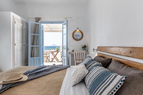 a bedroom with a bed with a view of the ocean at Studios Kontos in Mikri Vigla
