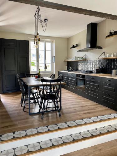 une cuisine avec une table et des chaises dans une cuisine dans l'établissement BENODET - Maison plage à pied - 4 chambres, à Bénodet