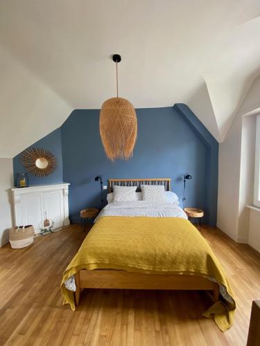 une chambre avec un lit avec un mur bleu dans l'établissement BENODET - Maison plage à pied - 4 chambres, à Bénodet