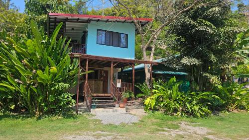 ein Haus mit einem blauen Dach und einer Veranda in der Unterkunft Bamboo River House and Hotel in Dominical