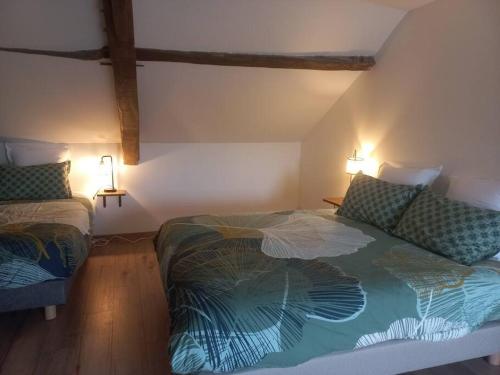 Saint-Georges-le-FléchardにあるGîte de la Petite Noërie - 11 personnesのベッドルーム1室(ベッド2台、壁に照明2つ付)