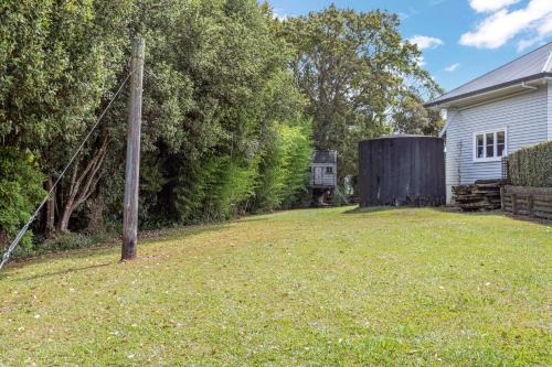 a yard with a wooden pole and a house at Countryside Haven Retreat with Pool and Deck in Clevedon