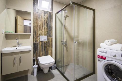 bagno con doccia, servizi igienici e lavatrice. di Tatiliniz için 45 Muhteşem Odalarımız Hazırdır. a Antalya (Adalia)