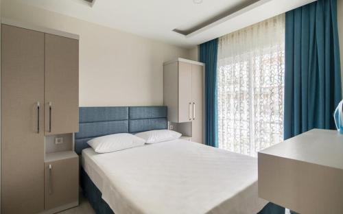 Un dormitorio con una cama grande y una ventana en Tatiliniz için 45 Muhteşem Odalarımız Hazırdır., en Antalya