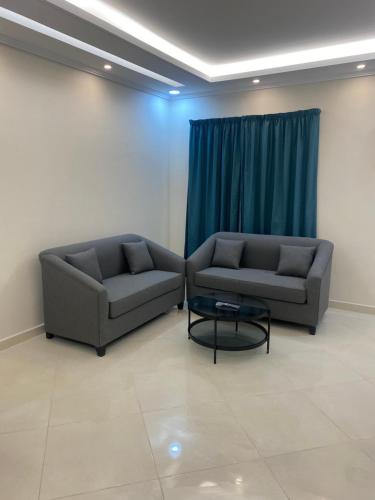 a living room with two couches and a table at شقق ضيافة رغد 2 in Al Madinah