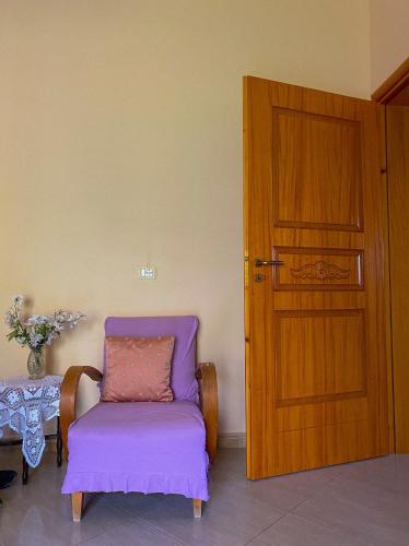a purple chair sitting next to a wooden door at Dhori House Dhermi in Dhërmi