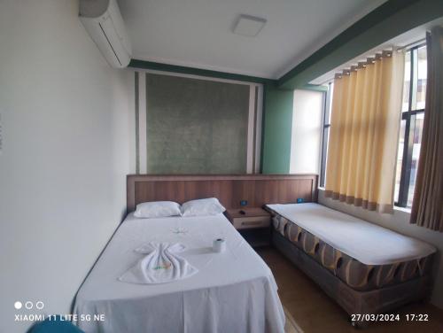 um quarto com duas camas e uma janela e uma cama e uma roupa de cama em casa sol residencial tarapoto em Tarapoto