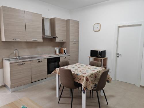 cocina con mesa con sillas y fregadero en Appartamento Dolce Casa, en Imola