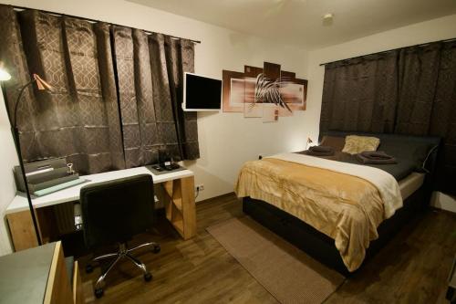 a bedroom with a bed and a desk and a computer at Serviced Business Apartment in Lorsch