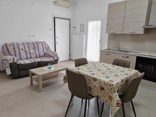 cocina y sala de estar con mesa y sofá en Appartamento Dolce Casa, en Imola