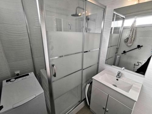 une salle de bain blanche avec un lavabo et une douche dans l'établissement Résidence Etoile Du Sud - 2 Pièces pour 4 Personnes 401, à Leucate