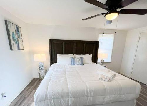 a bedroom with a large white bed with a ceiling fan at H2O Haven: 5 mins To Niagara Falls in Niagara Falls