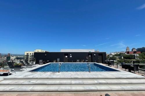 a swimming pool on the roof of a building at Condo moderne, centre-ville piscine, terrasse, gym in Quebec City