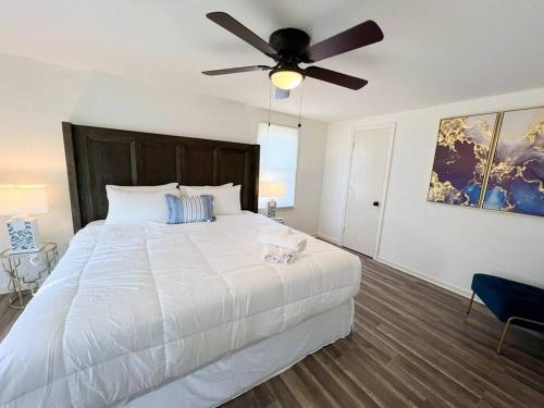 a bedroom with a large white bed with a ceiling fan at H2O Haven: 5 mins To Niagara Falls in Niagara Falls