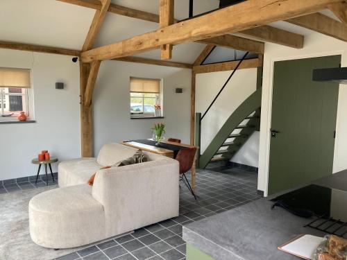 a living room with a couch and a staircase at De Rheebok in Uddel