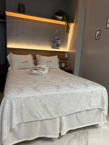 a white bed with a white comforter and pillows at Flat Jk 01 térreo in Juazeiro do Norte