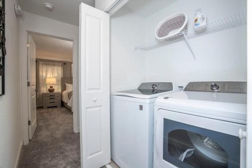 uma cozinha com uma máquina de lavar roupa e um lavatório em Gorgeous 4Bd Close to Disney with Pool at Storey Lake 4403 em Kissimmee
