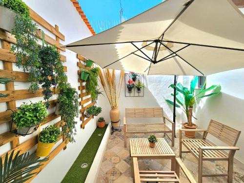 a patio with benches and plants on a building at Apartamentos de la Huerta in Alicante