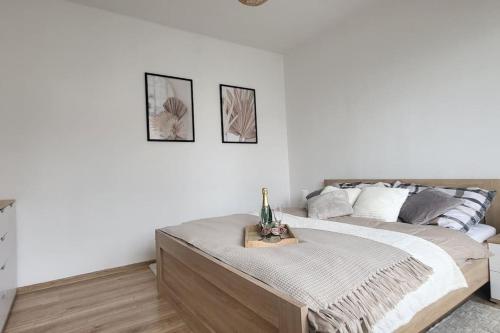a white bedroom with a bed with a bottle of champagne at Útulný byt v centru města in Rychnov nad Kněžnou