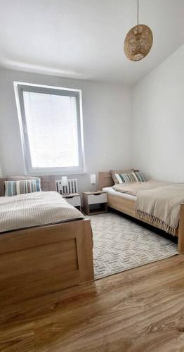 a bedroom with two beds and a window at Útulný byt v centru města in Rychnov nad Kněžnou