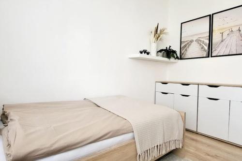 a white bedroom with a bed and white cabinets at Útulný byt v centru města in Rychnov nad Kněžnou