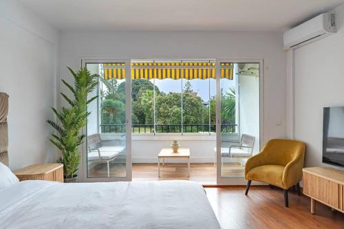 - une chambre avec un lit, une chaise et une fenêtre dans l'établissement Elegant Studio with Balcony, Pool & Parking, à Marbella