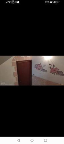 a picture of a bathroom with flowers on the wall at La Zàgara in Realmonte