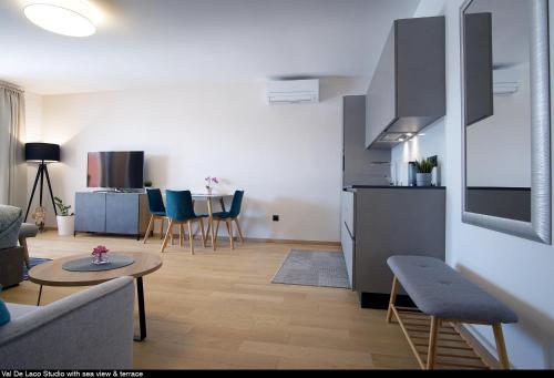 a living room with a couch and a table and a kitchen at Val De Laco studio apartments in Rovinj