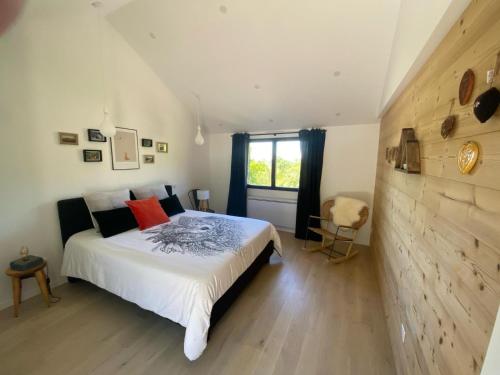 a bedroom with a large white bed and a window at L’ Annexe in Chariez