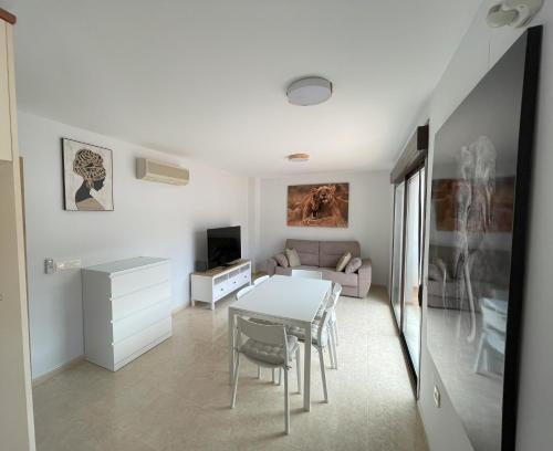 een witte woonkamer met een tafel en een bank bij Ático Carboneras con fantástica terraza in Carboneras