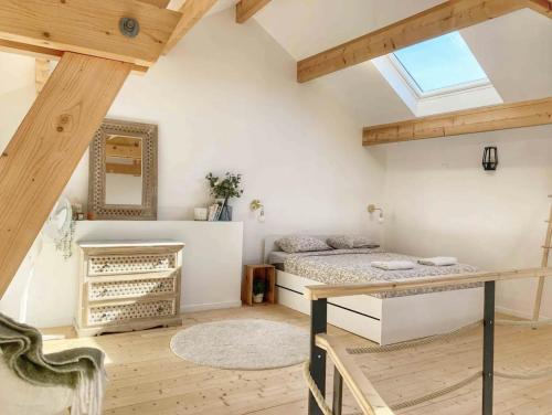 1 dormitorio con cama, escritorio y ventana en Magnifique grange rénovée au coeur de la Champagne, en Les Mesneux