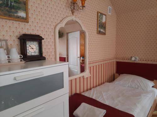 a bedroom with a bed and a mirror and a clock at Noclegi Sylana in Kobyłka