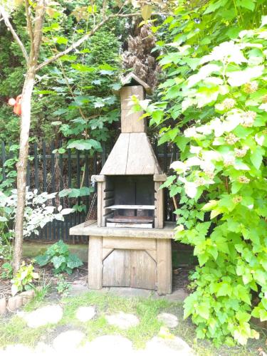 a wooden bird house sitting in a garden at Noclegi Sylana in Kobyłka