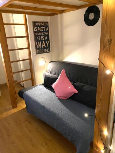 a black couch with a pink pillow in a room at Cozy nest, Kamppi in Helsinki