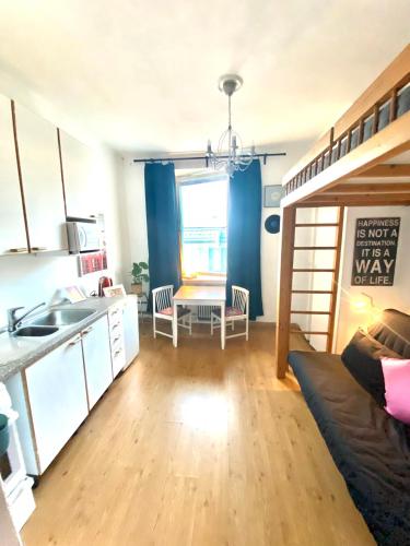 a kitchen and a living room with a bunk bed at Cozy nest, Kamppi in Helsinki