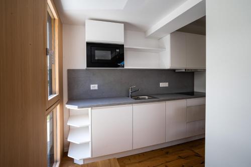 a kitchen with white cabinets and a sink at LUCKA BLED quiet location, free bikes, big garden, doctor in Bled