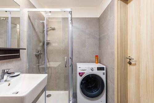 een badkamer met een wasmachine en een wastafel bij BNB : Sporty Studio Serenity in Bratislava