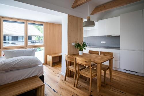 a bedroom with a table and a bed and a kitchen at LUCKA BLED quiet location, free bikes, big garden, doctor in Bled