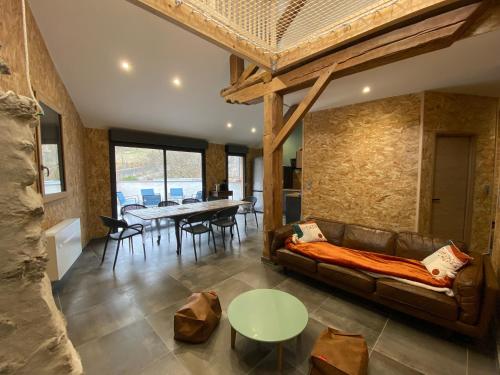 a living room with a couch and a table at Grange rénovée, 6 minutes du Lac d'Annecy vue sur le Mont-Blanc in Giez