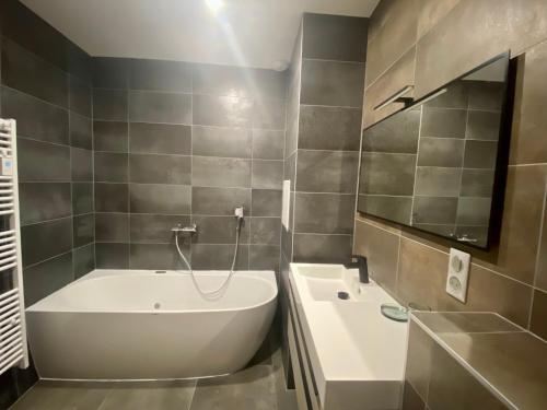 a bathroom with a bath tub and a sink at Grange rénovée, 6 minutes du Lac d'Annecy vue sur le Mont-Blanc in Giez